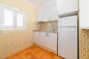 a kitchen with a white refrigerator and a window at Atlas Apartments Ibiza in Santa Eularia des Riu +72 photos