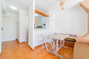 een eetkamer met een houten tafel en stoelen bij Atlas Apartments Ibiza in Santa Eularia des Riu