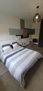 a large white bed in a room with a desk at Appartement 2 chambres in Le Born