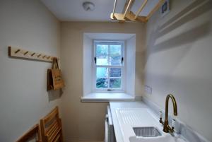 une cuisine avec un évier et une fenêtre dans l'établissement Sea Holly Cottage- coastal retreat Pittenweem, à Pittenweem 41 autres photos