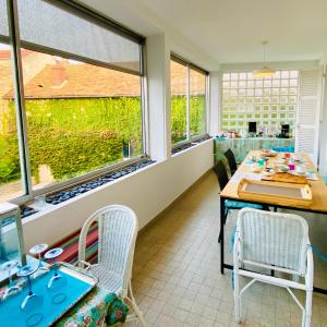 La Dormance في بون: غرفة طعام مع طاولة وكراسي ونوافذ