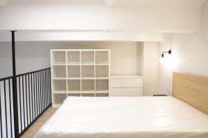 a bedroom with a large white bed and shelves at Sniego Apartments in Vilnius