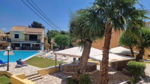 a resort with a pool and palm trees at Meraki Kavos in Kavos