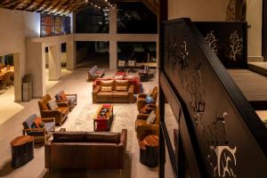 una sala de estar con sofás y sillas y una escalera en Chobe River Lodge en Kasane