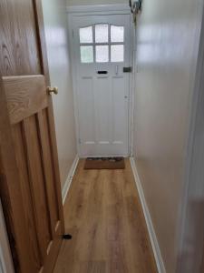 um corredor com uma porta branca e uma janela em Grace Lodge em Southbourne