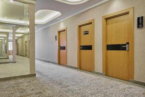 a row of wooden doors in a hallway at Al Anvar Halal Hotel by HotelPro group in Tashkent