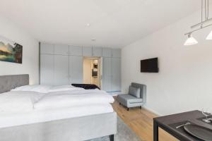 ein Schlafzimmer mit einem Bett, einem Stuhl und einem Waschbecken in der Unterkunft Apartment BERGBLICK in Bad Reichenhall