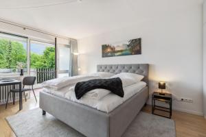 a bedroom with a large bed in a room with a balcony at Apartment BERGBLICK in Bad Reichenhall