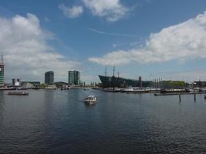 a small boat in a harbor with boats in the water at Intersail Hostel - Avontuur in Amsterdam