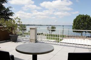 a patio with a table and a view of the water at Hotel Campanello in Castelnuovo del Garda