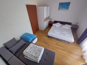 ein Wohnzimmer mit einem Sofa und einem Bett in der Unterkunft Apartmani Vuković in Kaprije