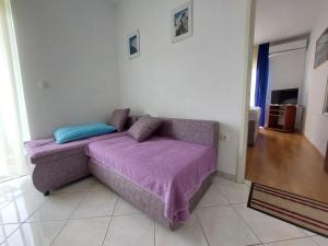 a couch with a purple blanket in a room at Apartmani Vuković in Kaprije