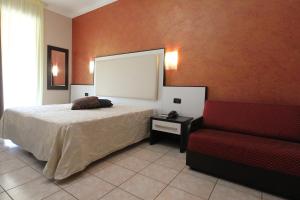 a bedroom with a bed and a red couch at Hotel Campanello in Castelnuovo del Garda