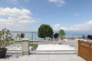 a white fence with a view of the water at Hotel Campanello in Castelnuovo del Garda