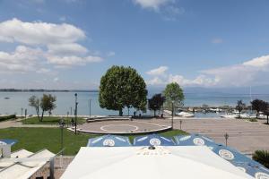 a large white tent in a park next to a body of water at Hotel Campanello in Castelnuovo del Garda