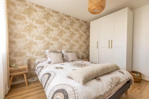 een slaapkamer met een groot bed en witte kasten bij *Cocoon Area* Confort & Parking in Clermont-Ferrand
