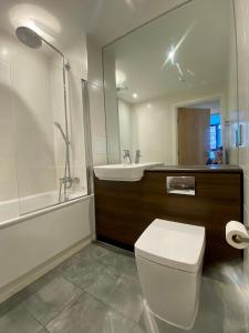a bathroom with a toilet and a sink and a shower at Stunning & Luxury Flat in Sutton