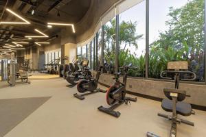 a row of exercise bikes in a gym with windows at SUN & MOON, Riverside Hotel in Phnom Penh