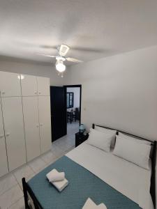 a bedroom with a bed and a ceiling fan at Brilliance Apartments in Ouranoupoli