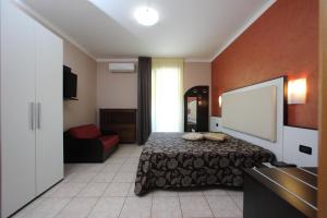 a hotel room with a bed and a couch at Hotel Campanello in Castelnuovo del Garda