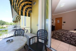 a room with two chairs and a table and a bed at Hotel Campanello in Castelnuovo del Garda