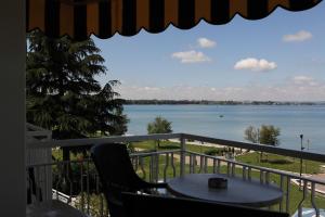a balcony with a table and a view of the water at Hotel Campanello in Castelnuovo del Garda
