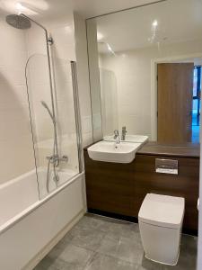 a bathroom with a toilet and a sink and a shower at Stunning & Luxury Flat in Sutton
