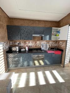 a kitchen with stainless steel appliances in a room at Superbe appartement luxueux idéalement situé à la marina saidia in Saïdia