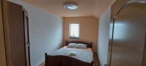 ein kleines Schlafzimmer mit einem Bett und einem Fenster in der Unterkunft Apartman Citadel in Gradačac