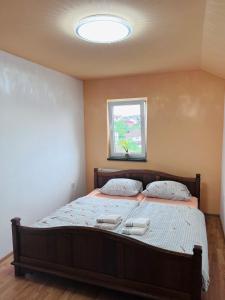 Schlafzimmer mit einem großen Bett und einem Fenster in der Unterkunft Apartman Citadel in Gradačac