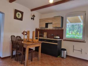 a kitchen with a wooden table and a sink at Dom wakacyjny nad jeziorem w Jodłowie II in Jodlow