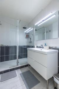 een badkamer met een witte wastafel en een douche bij *Cocoon Area* Confort & Parking in Clermont-Ferrand
