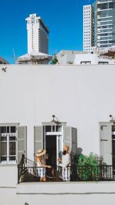 Dos personas sentadas en el balcón de un edificio en Allegro Neve Tzedek Boutique Suites - By HOMY en Tel Aviv