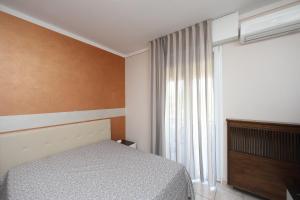 a bedroom with a bed and a window at Hotel Campanello in Castelnuovo del Garda