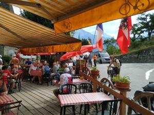 a group of people sitting at an outdoor restaurant at Appartement rez de jardin montée de l'alpe d'Huez in La Garde