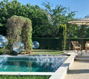 un jardin avec une piscine à bulles dans l'eau dans l'établissement LA GRANDE MAISON LGM, à Lesches