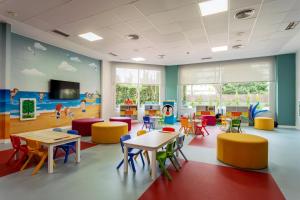 a classroom with tables and chairs and a play area at Ponient Pirámide Salou by PortAventura World in Salou