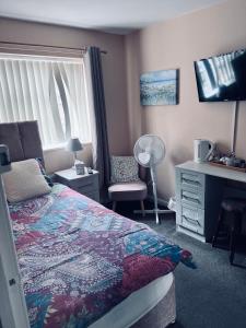 a bedroom with a bed and a desk and a window at The Mallards in Sleaford