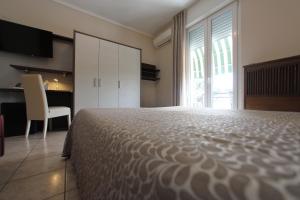 - une chambre avec un lit, un bureau et une chaise dans l'établissement Hotel Campanello, à Castelnuovo del Garda