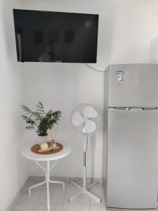 a room with a table and a tv on the wall at Brilliance Sea View Apartments in Ouranoupoli