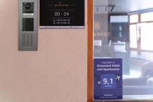 um relógio numa parede com um sinal em Ornament Hotel and Apartments em Saraievo