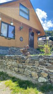 una casa con una pared de piedra frente a una casa en Zlatna koliba Namir Zuka, en Fojnica