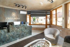 a lobby with a reception desk and a chair at Ornament Hotel and Apartments in Sarajevo