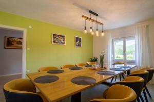 a dining room with a large wooden table and chairs at Plum house - villa with pool in Gospić