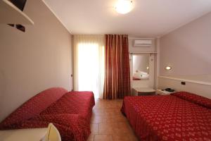 カステルヌオーヴォ・デル・ガルダにあるHotel Campanelloのベッド2台と窓が備わるホテルルームです。