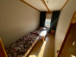 um pequeno quarto com uma cama e uma janela em Ūdensdzirnavas em Strazde