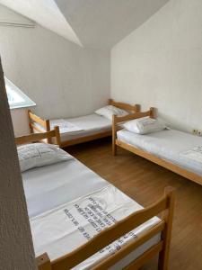 a room with three beds in a room at Hostel Heimli in Pristina