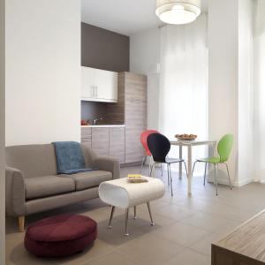 sala de estar con sofá, sillas y mesa en UP to home - Residenze Milano, en Milán