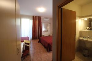 a hotel room with a bed and a bathroom at Hotel Campanello in Castelnuovo del Garda