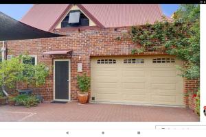 uma casa de tijolos com garagem com porta em Snow-white's 2 bedroom City heart Cottage in Perth 6000 em Perth